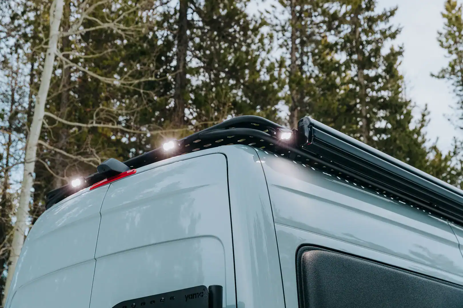 Roof-rack lighting on the Yama Vans Furō illuminated in a forest