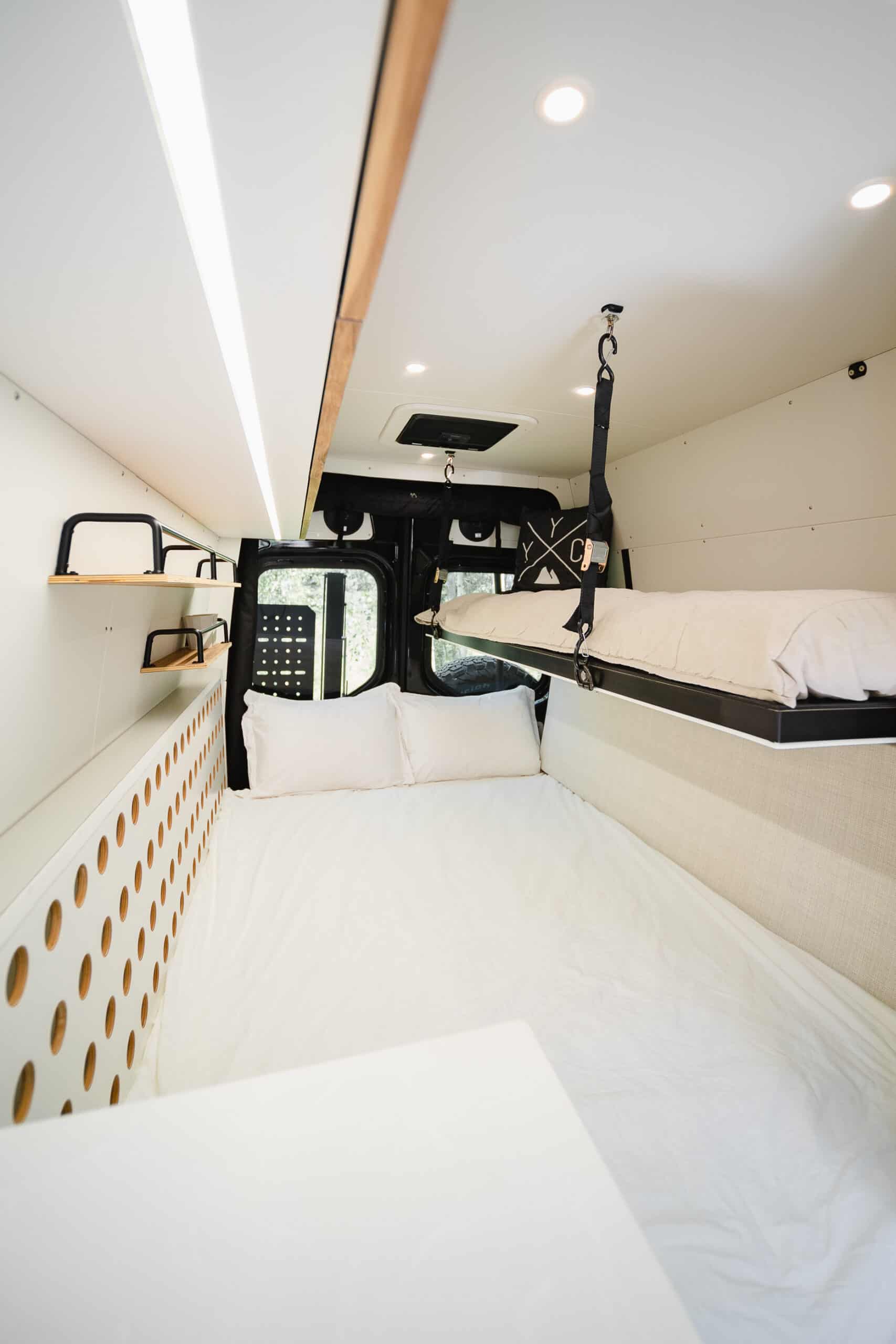 The rear sideways bed and flip-down bunk inside the Yama Vans Gatsby