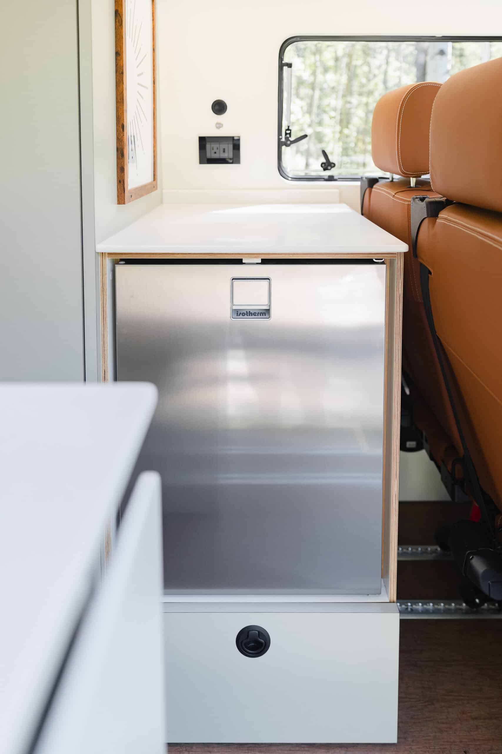A stainless compressor refrigerator built into the cabinetry of the Yama Vans Gatsby