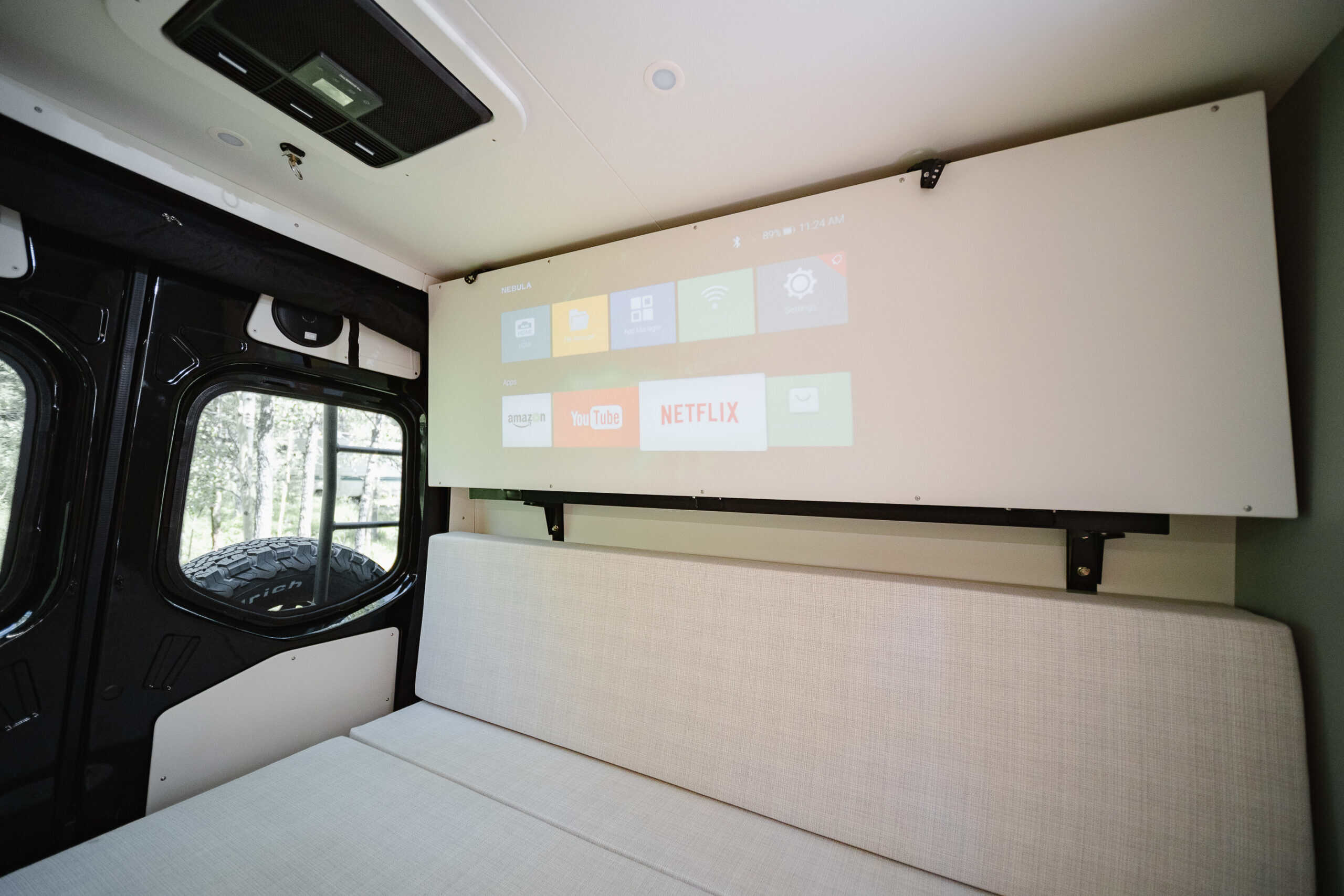 An onboard movie projector displaying a streaming menu inside the Yama Vans Gatsby