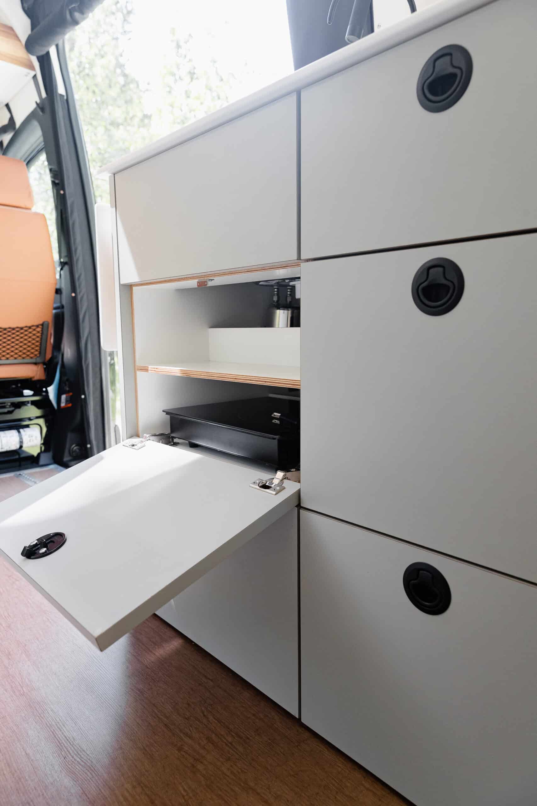 A pull-out desk and storage cabinetry inside the Yama Vans Gatsby
