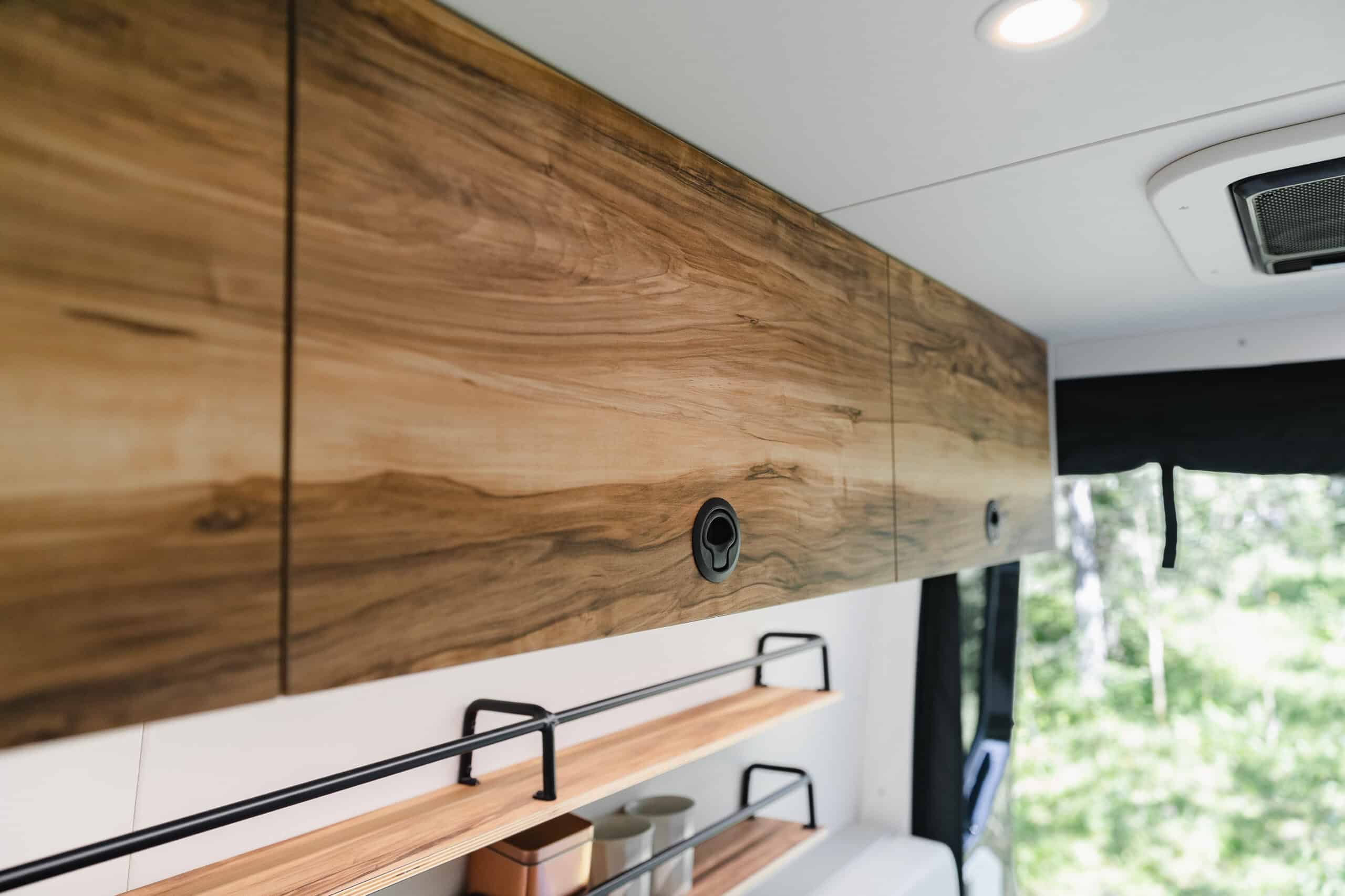 Figured-wood upper cabinetry and open shelving inside the Yama Vans Gatsby