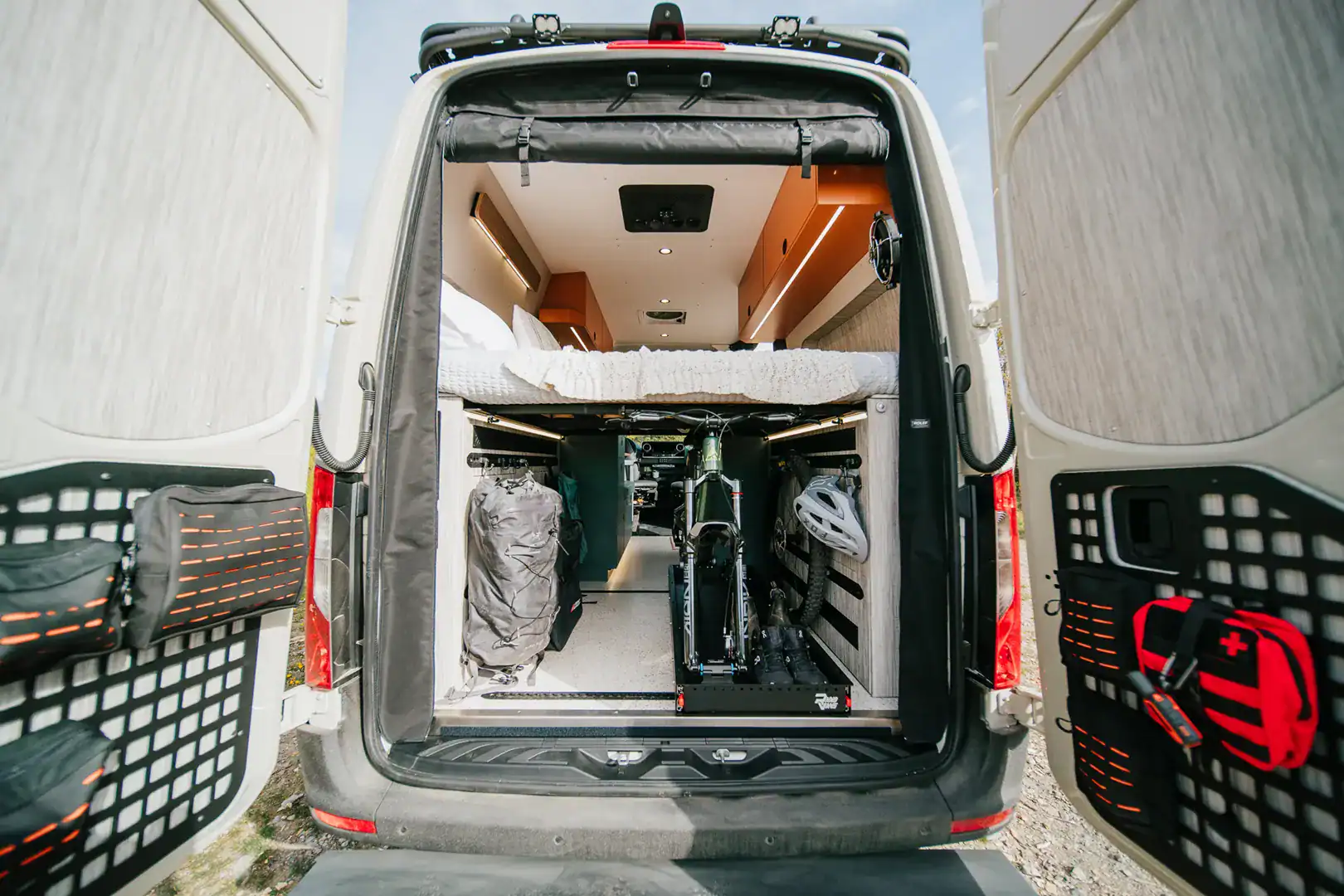 The rear gear garage of the Yama Vans Taiyō loaded with two mountain bikes beneath the elevated bed