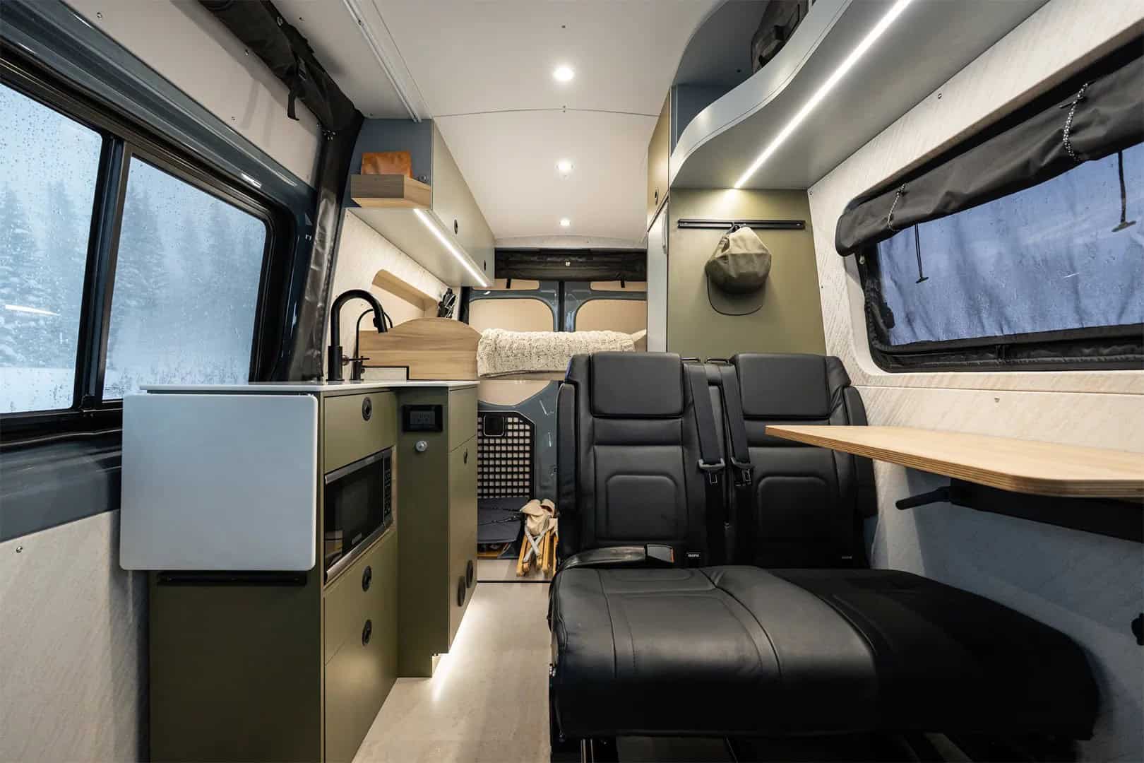 Interior of the Yama Vans Teton 01N showing galley kitchen, rear seating, and elevated bed