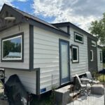Tiny house on wheels with a bedroom in Montana for small space living.