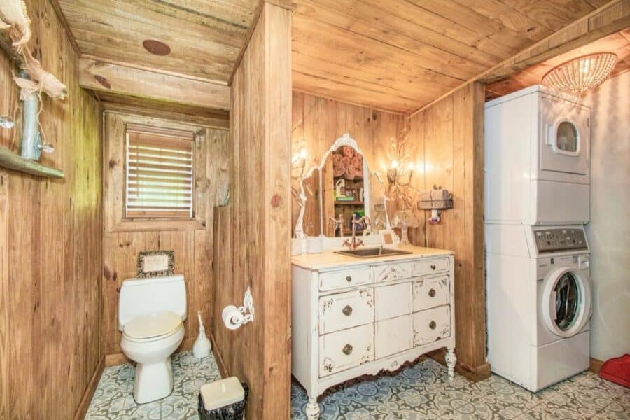 Charming rustic bathroom in a small farm cottage with wooden walls and vintage decor.
