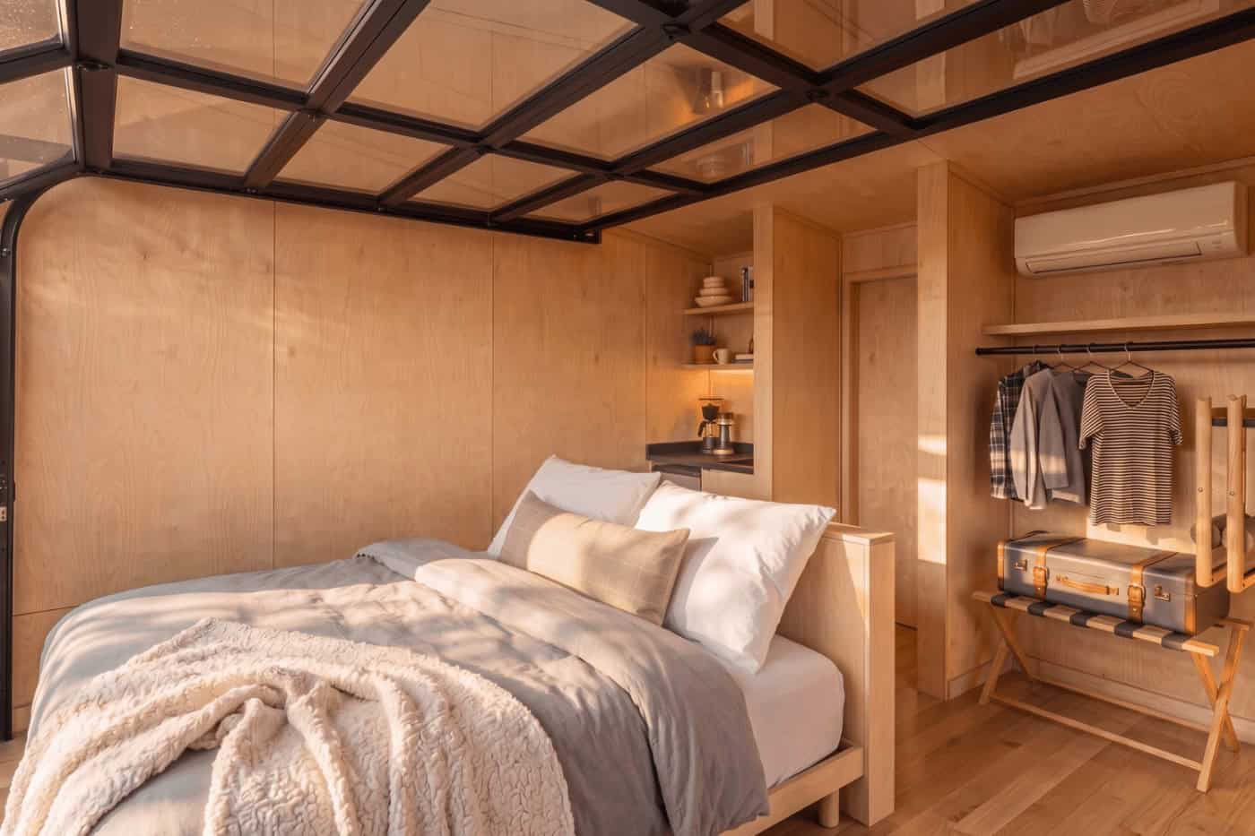 Bedroom area with open closet and mini-split in the Atlas park model by Zook Cabins