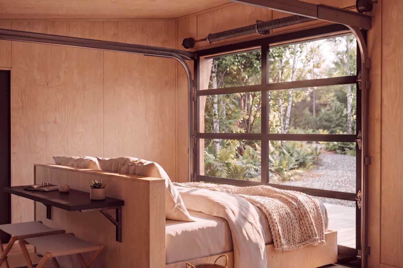 View through the open glass garage door from inside the Atlas park model by Zook Cabins