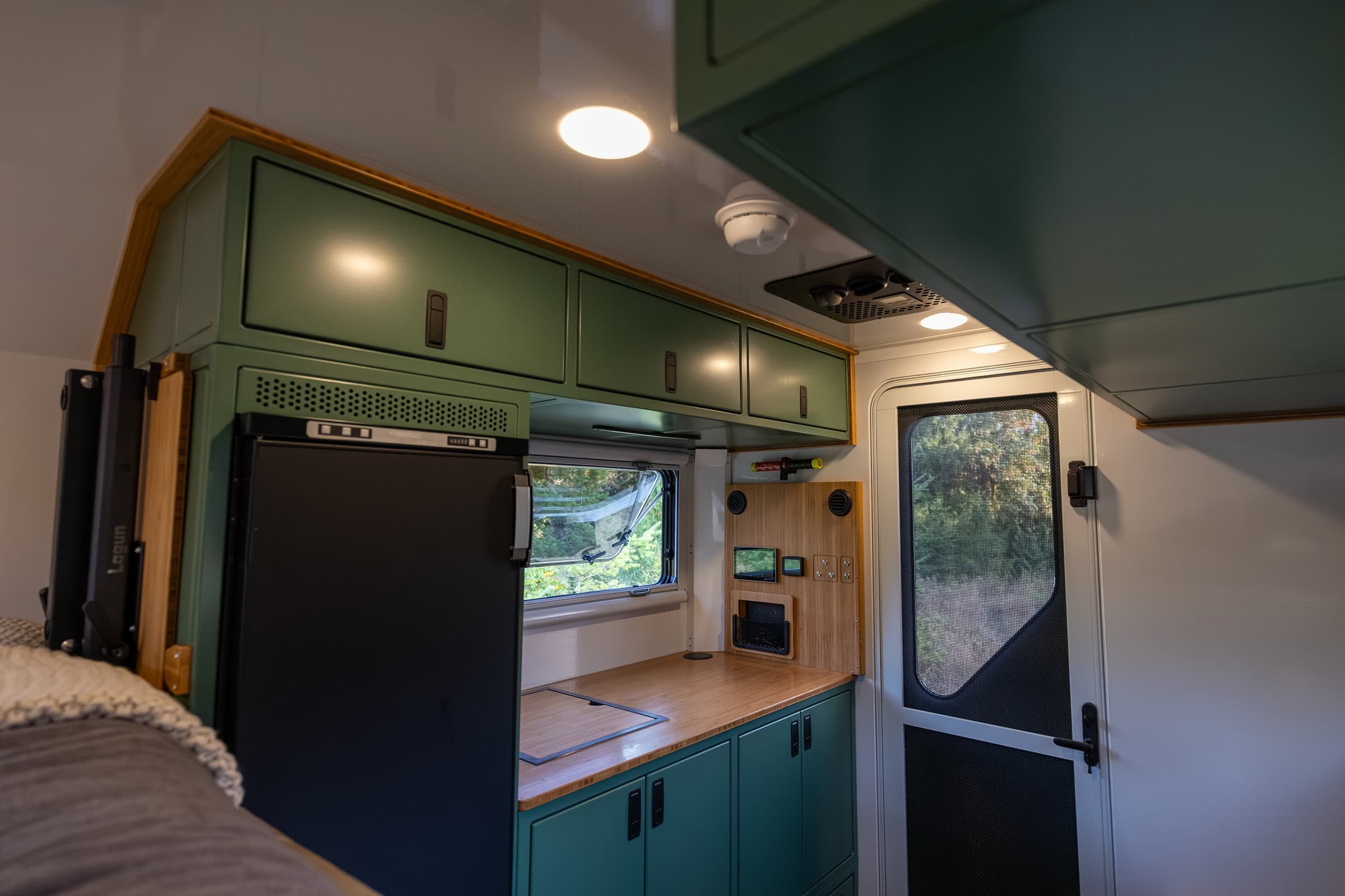 Galley interior with cabinets, fridge, and counter