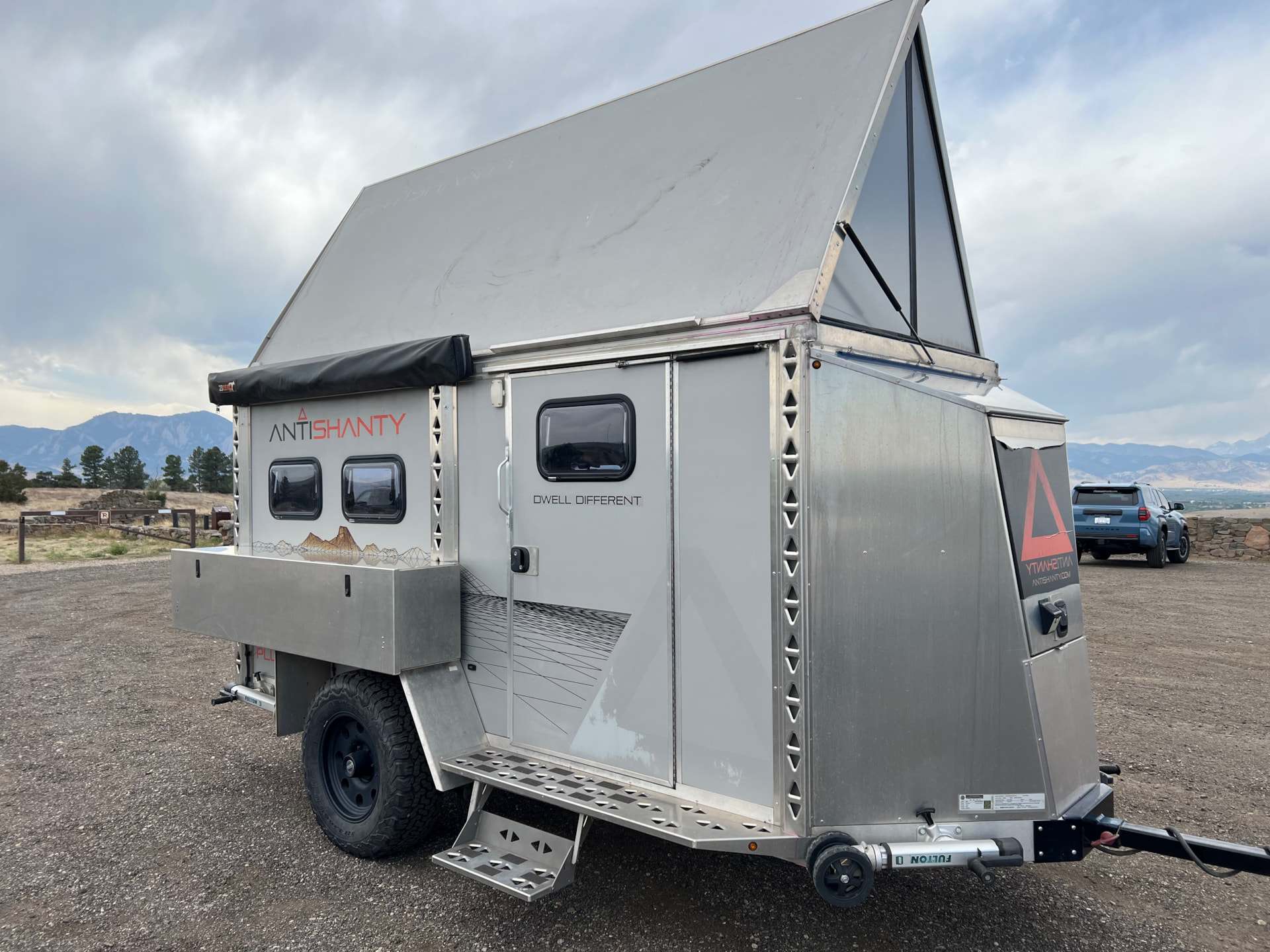 AntiShanty AS-1 Plus in camp mode with hard-sided A-frame roof popped up, side door, entry step, and stowed awning