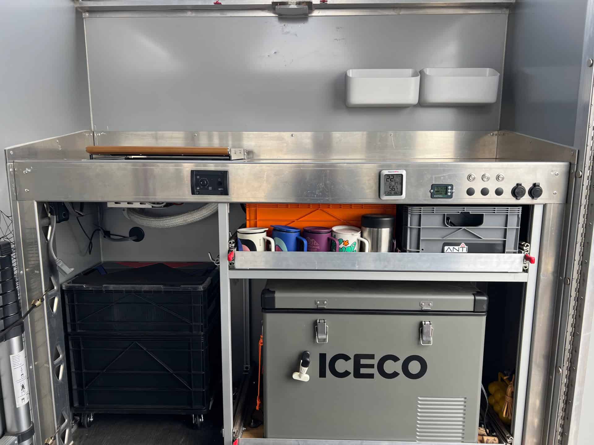 Passenger-side kitchen box with Wallas diesel stove, ICECO compressor fridge on a custom slide, and drawer storage