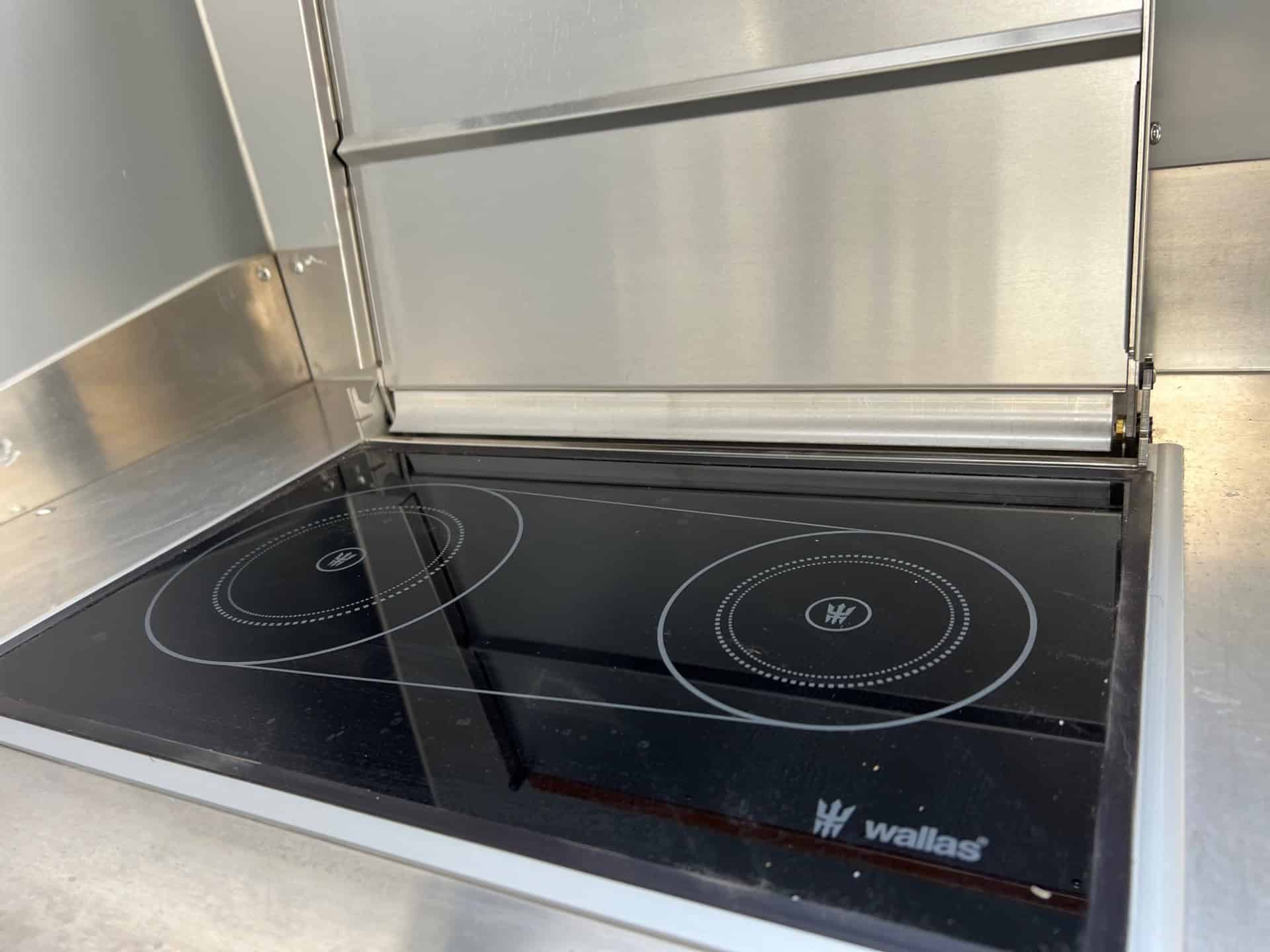 Close-up of the built-in Wallas two-burner diesel cooktop and heater in the aluminum kitchen counter