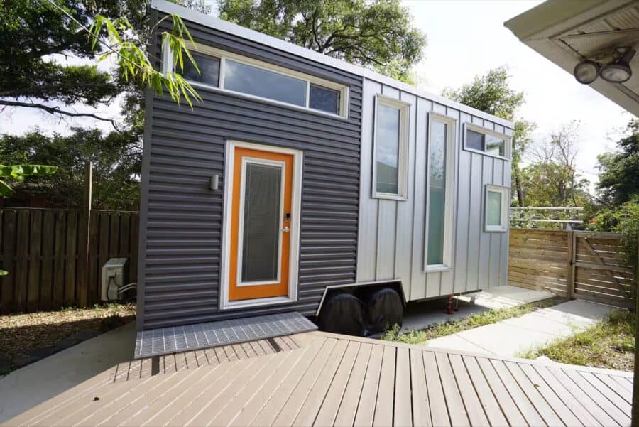 Compact tiny house on wheels with sleek exterior and large windows for natural light.