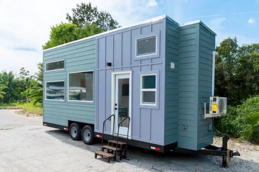 Updated Avalon 24' tiny house by Dragon Tiny Homes — blue and lavender exterior on a double-axle trailer