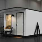 Compact tiny house with sleek white exterior and black trim, ideal for affordable living.