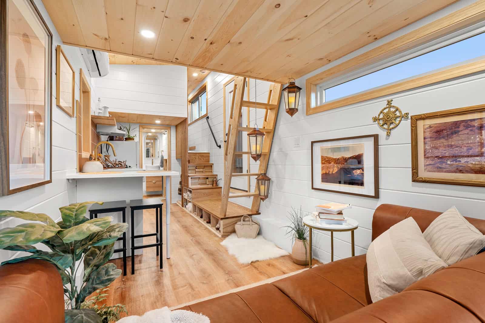 Honey Bee interior: white shiplap corridor from living through kitchen bar toward dual loft access and bath
