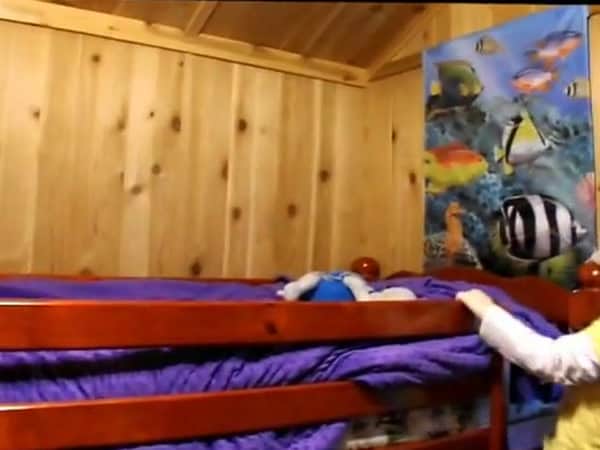 Kids bunk room with wooden bunk beds and knotty pine walls in the Baird family tiny cabin