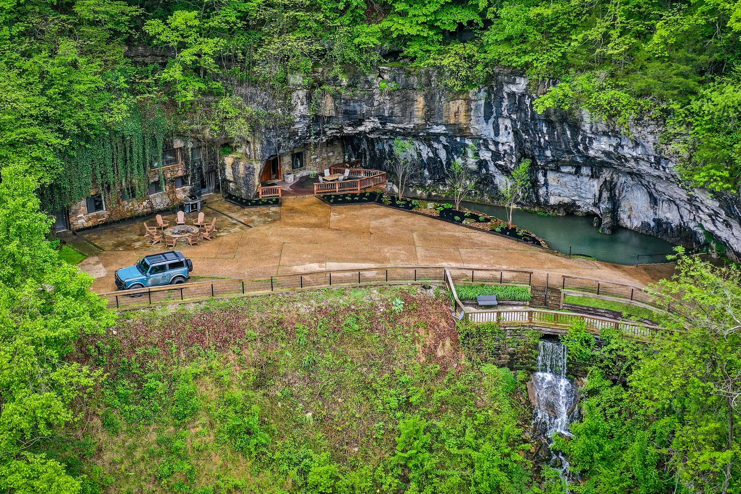 Aerial of the cave mouth, courtyard, and a falls below