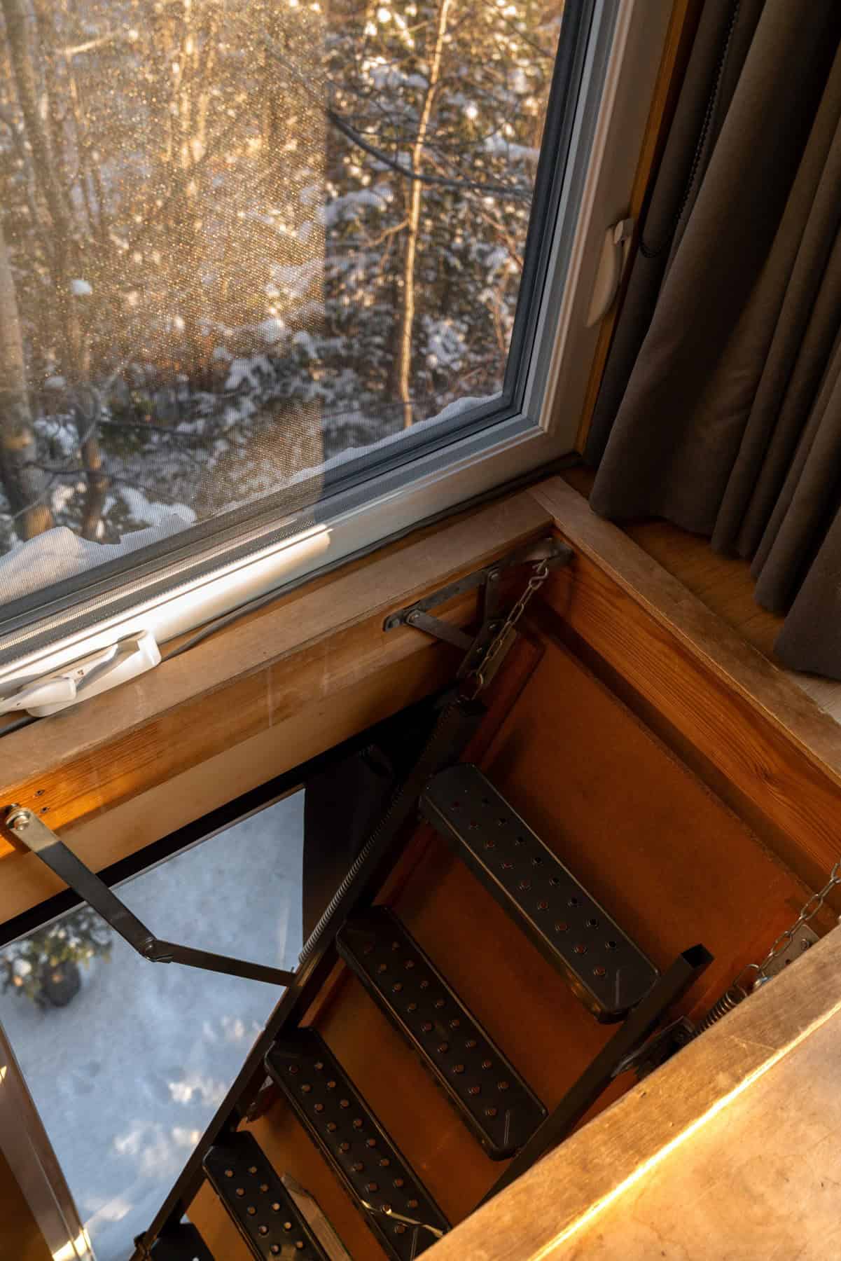 Loft hatch with metal stair and snowy window inside BESIDE LAO Canopée