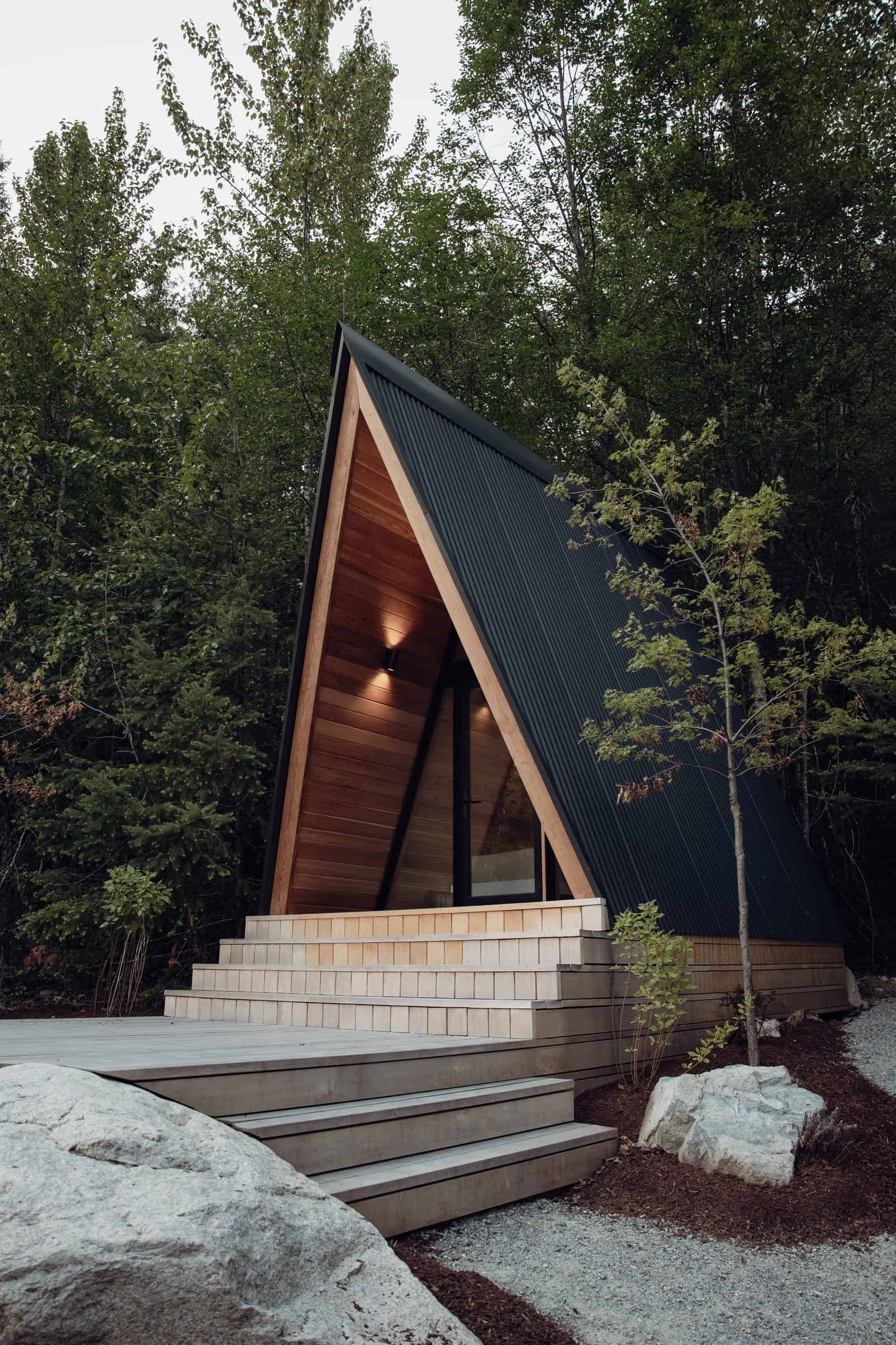 System 00 black metal A-frame on multi-tier deck with wood-lined porch in forest