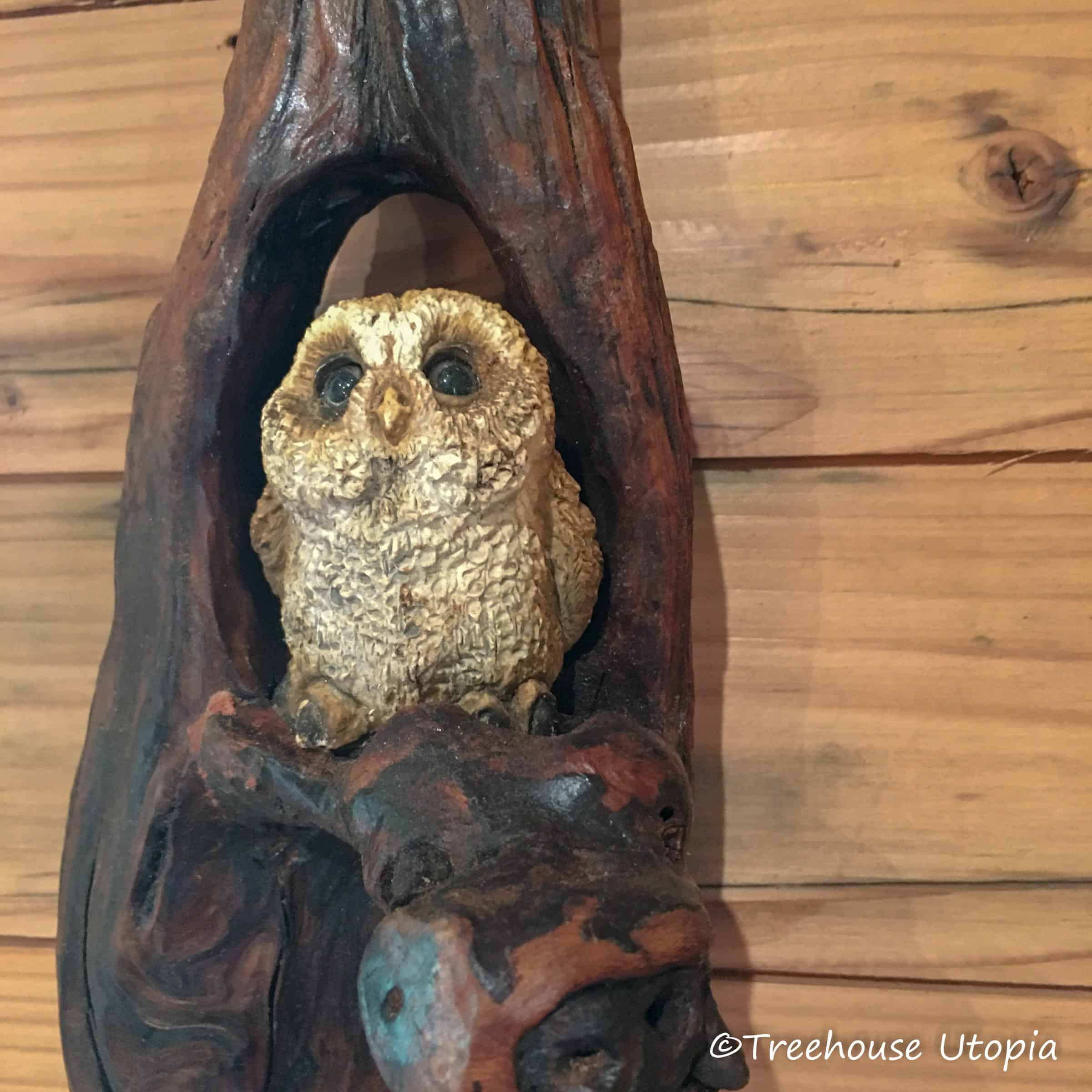 A carved owl figurine set in a hollow of wood