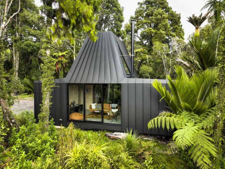 Black Biv cabin in Punakaiki ferns with open glass to the living room, no channel logo