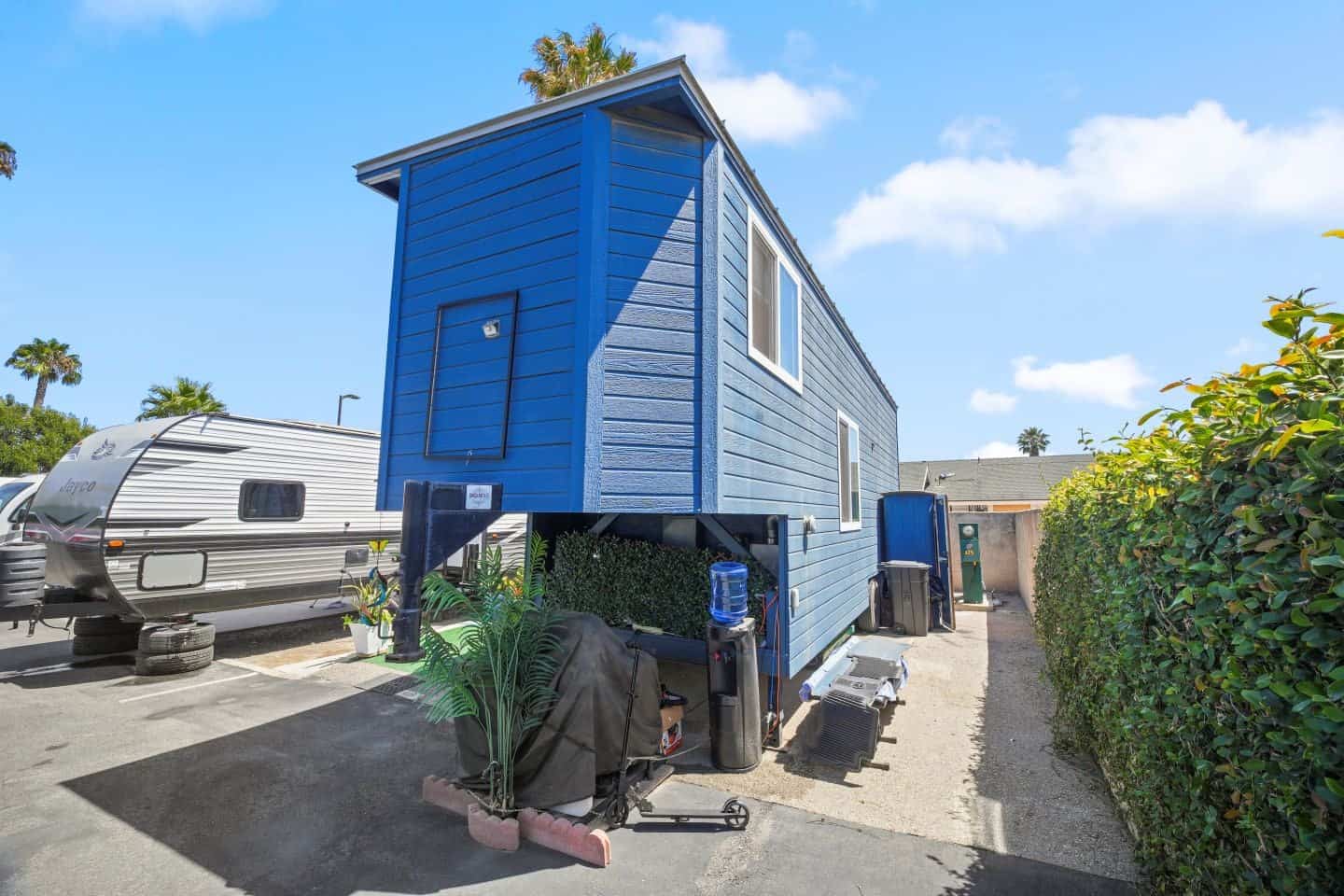 Gooseneck end of the blue tiny house on wheels showing the raised bedroom section over the hitch