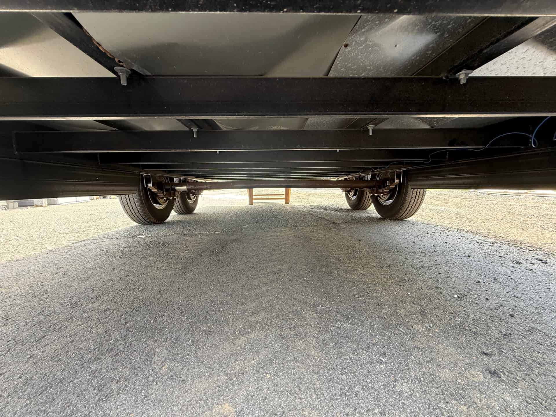 Underside of the dual-axle steel trailer frame under the cottage