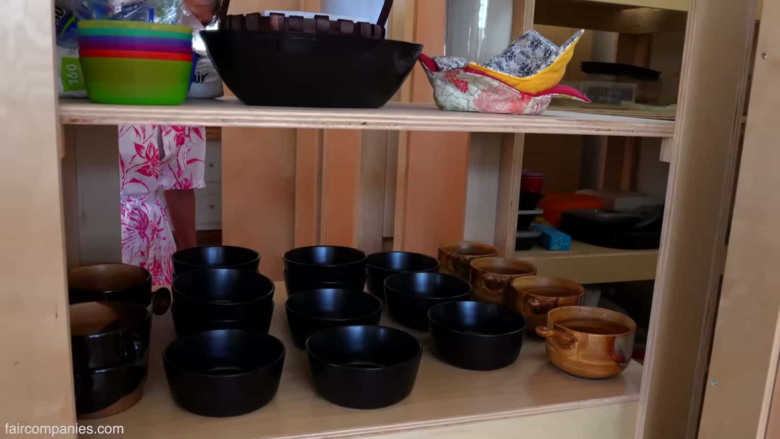 Rolling pantry cabinet with bowls and dishware on open shelves
