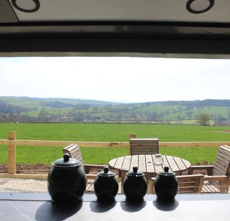 View from the breakfast bar through the bus window to the patio and rolling fields