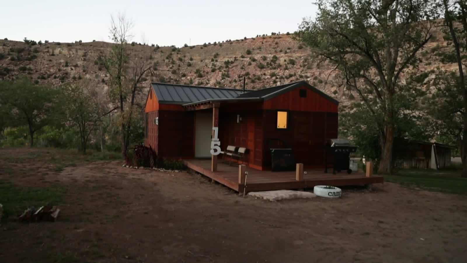 Restored historic cabin with a wood deck and covered porch at Camp V
