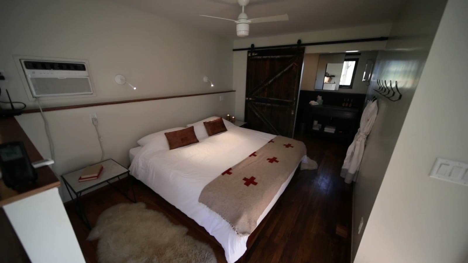 King bed and reclaimed sliding barn door in a Camp V studio cabin