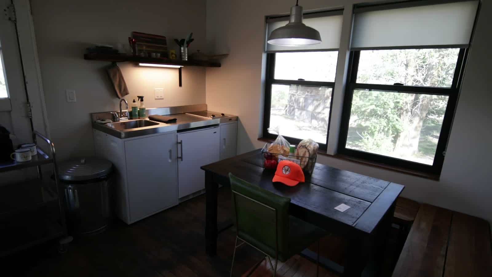 Compact kitchenette and dining table inside a restored Camp V cabin