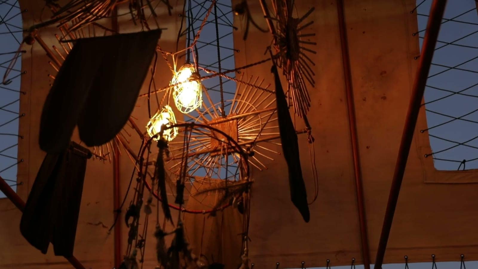 Warm hanging lights and found-object art inside the Prairie Wind Chapel at night