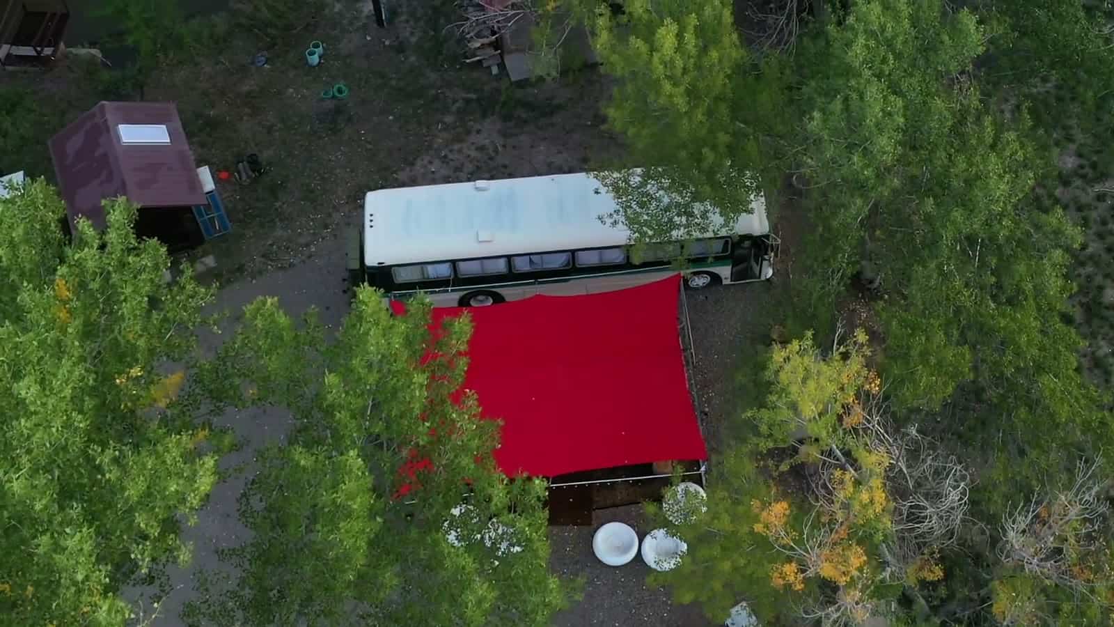 Aerial view of the Magic Bus speakeasy with its red shade canopy among cottonwood trees