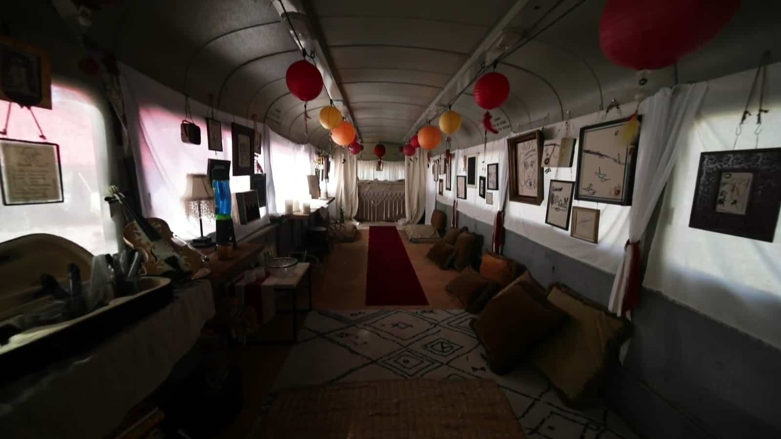 Interior of the Magic Bus lined with framed guest drawings and paper lanterns