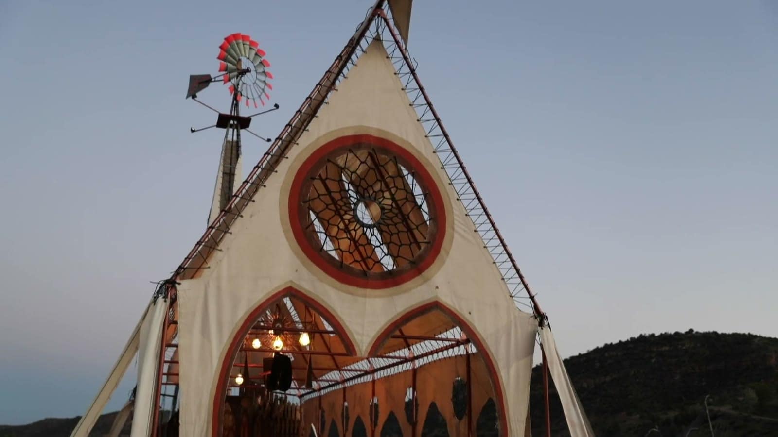 Front of the Prairie Wind Chapel with its round stained-glass style window and windmill