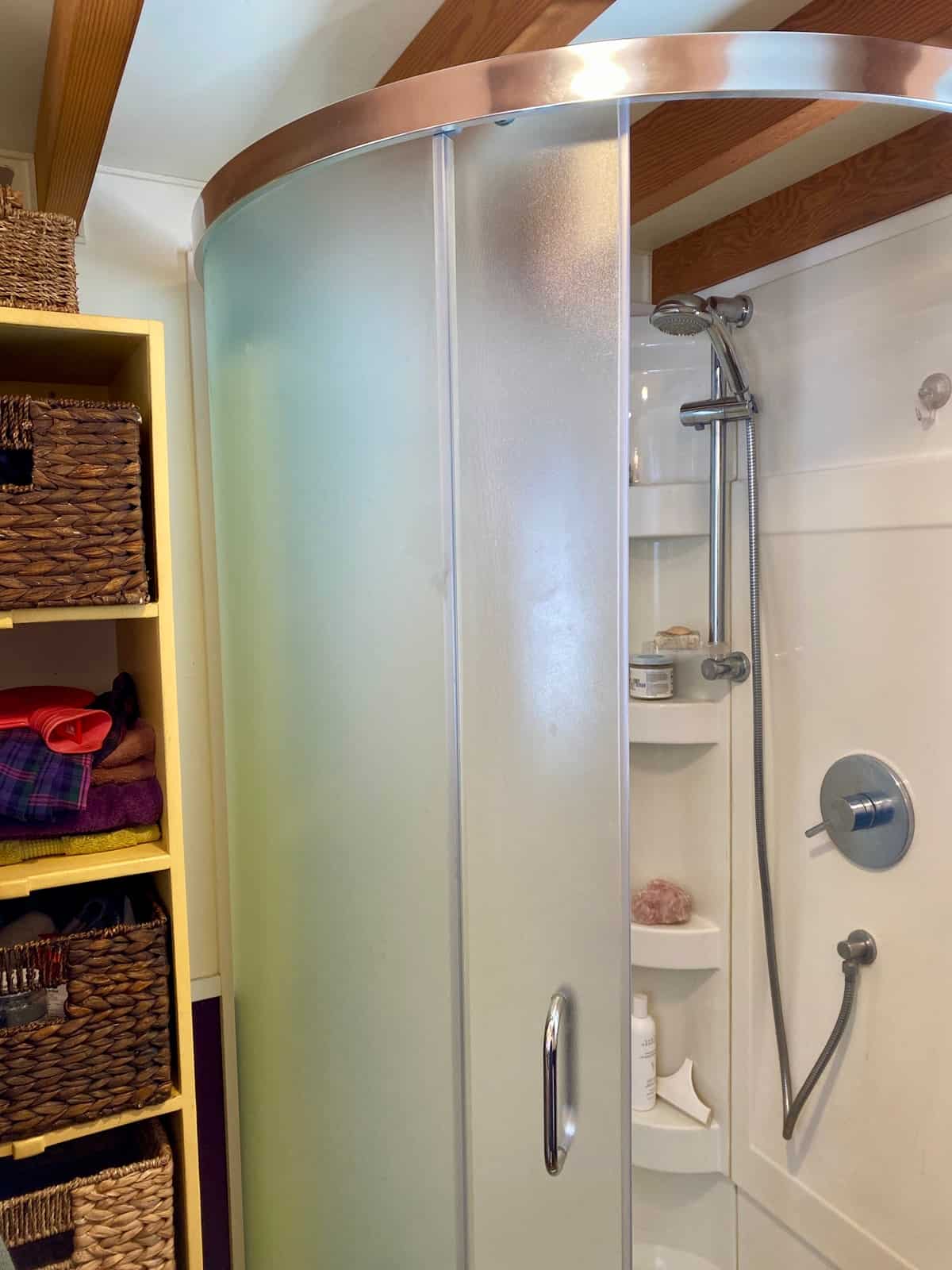 Rounded corner shower with frosted glass doors and storage shelves