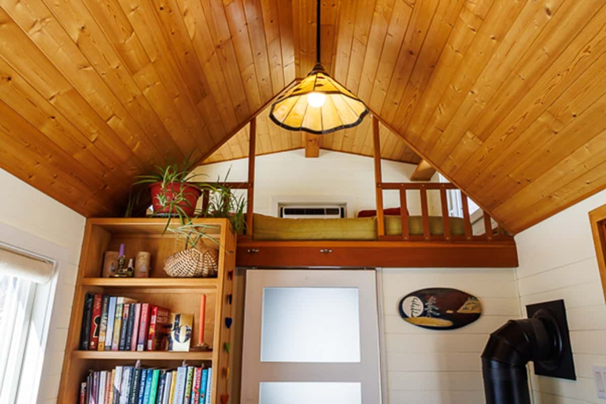 Guest loft over the bathroom with a frosted door below and pendant light