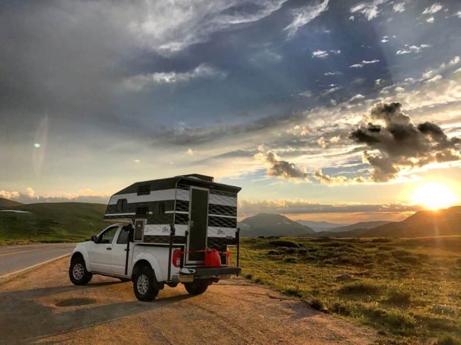 Capri Camper Retreat on a white pickup at a mountain overlook at sunset