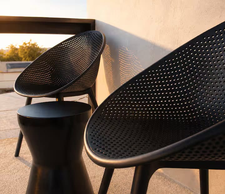 Black woven chairs and a side table on the balcony