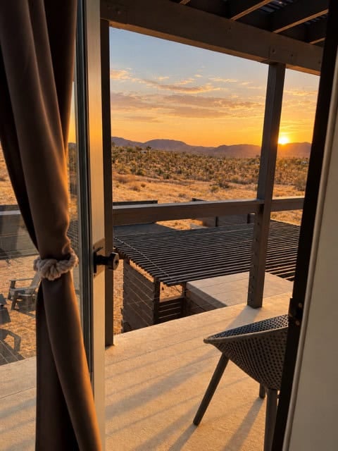 View from the upstairs doorway onto the balcony and the desert at sunset