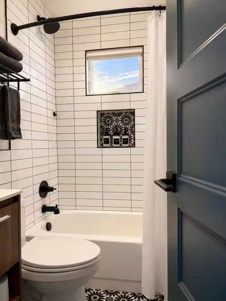 Bathroom with white subway tile, a tub-shower combination and matte black fixtures