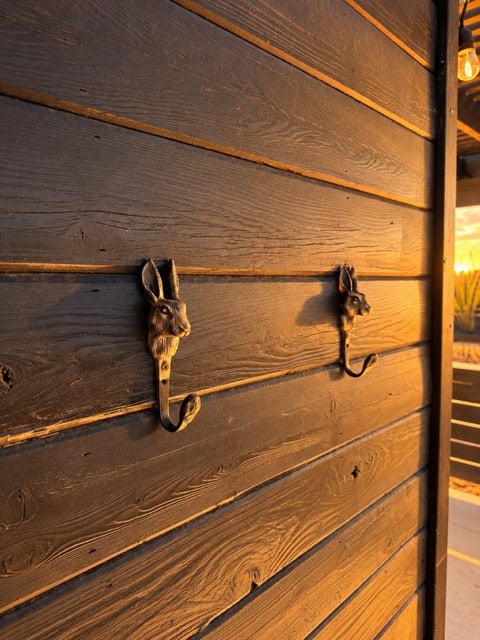 Rabbit-shaped metal hooks on a dark wood wall