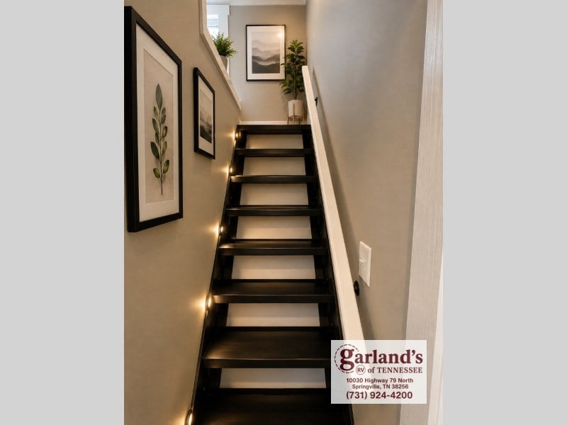 Black stairs with white risers leading up to the loft
