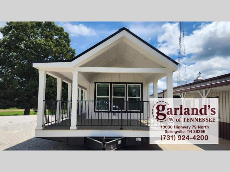 Clayton Wheeler park model on the dealer lot with a large covered front porch and black railings