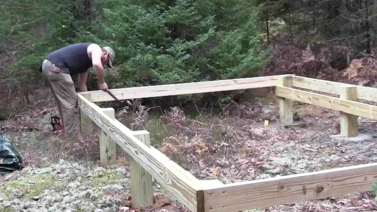 Treated post foundation and floor frame for a 10x16 cabin in the woods