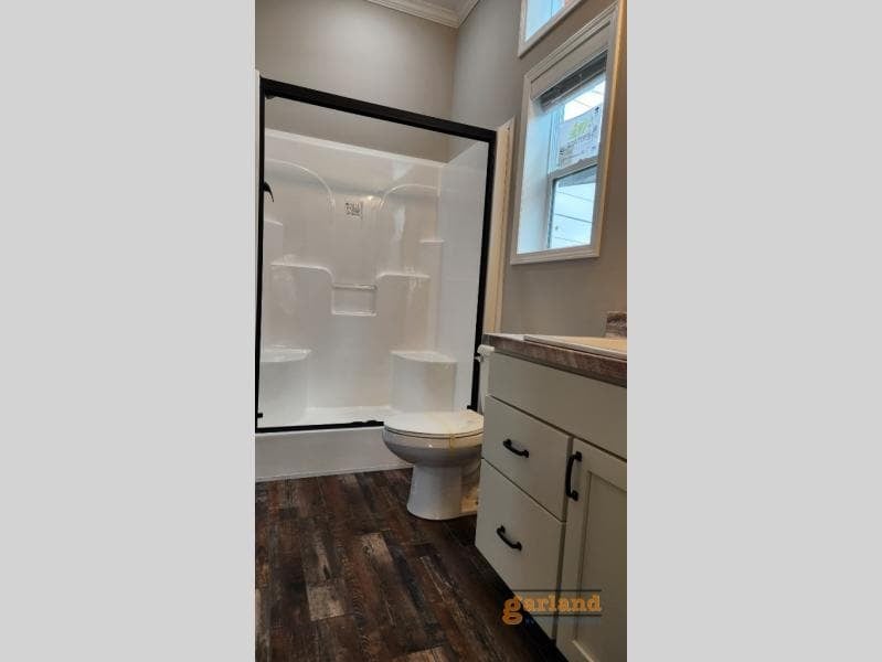 Cozy Cabin walk-in shower with black-framed glass and built-in seats