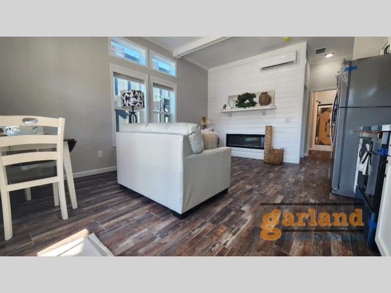 Cozy Cabin living wall: white shiplap, recessed electric fireplace under mantel, mini-split above