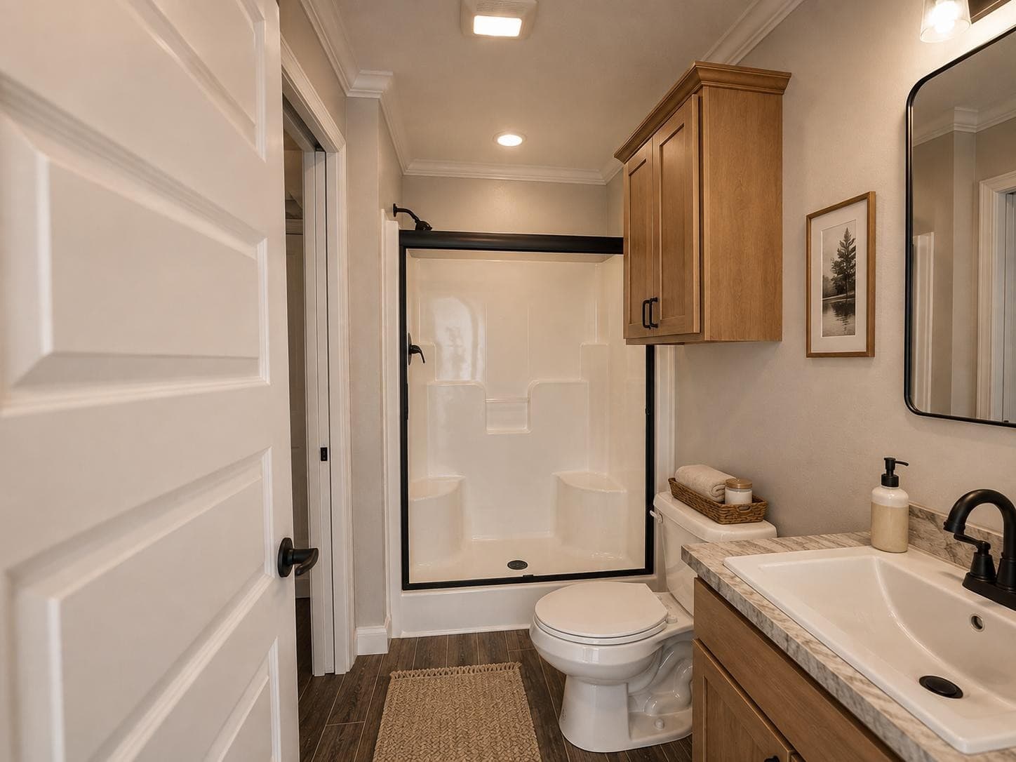 Fawn Unlimited bath: black-framed glass shower with built-in seats, toilet, light-wood vanity
